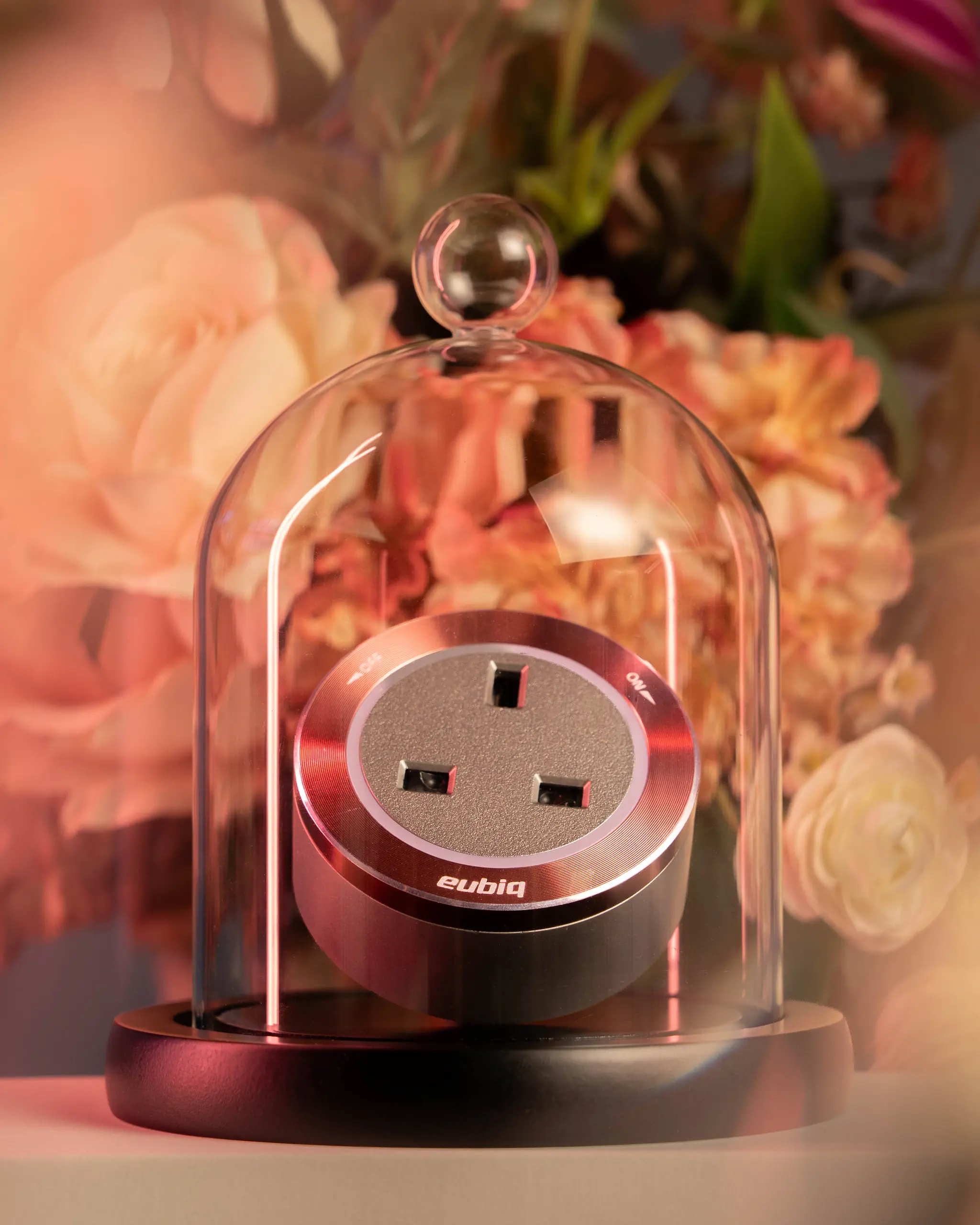 Eubiq power adapter presented in a glass with a soft pink floral backdrop for Mother's Day.